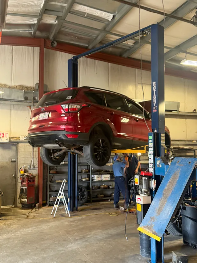 Red SUV on a workshop lift