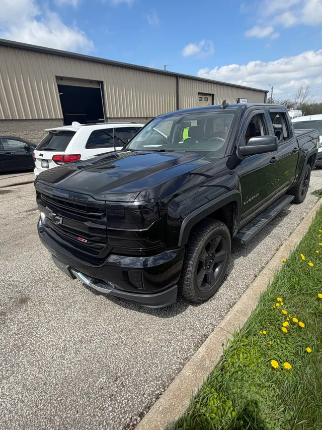Black pickup parked beside the workshop