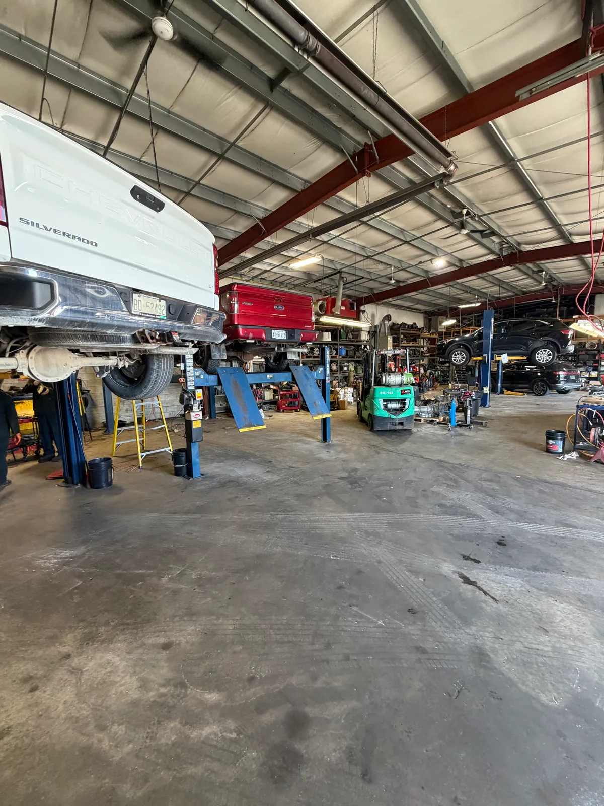 Inside the WorldWide Transmissions workshop, with vehicles on service lifts